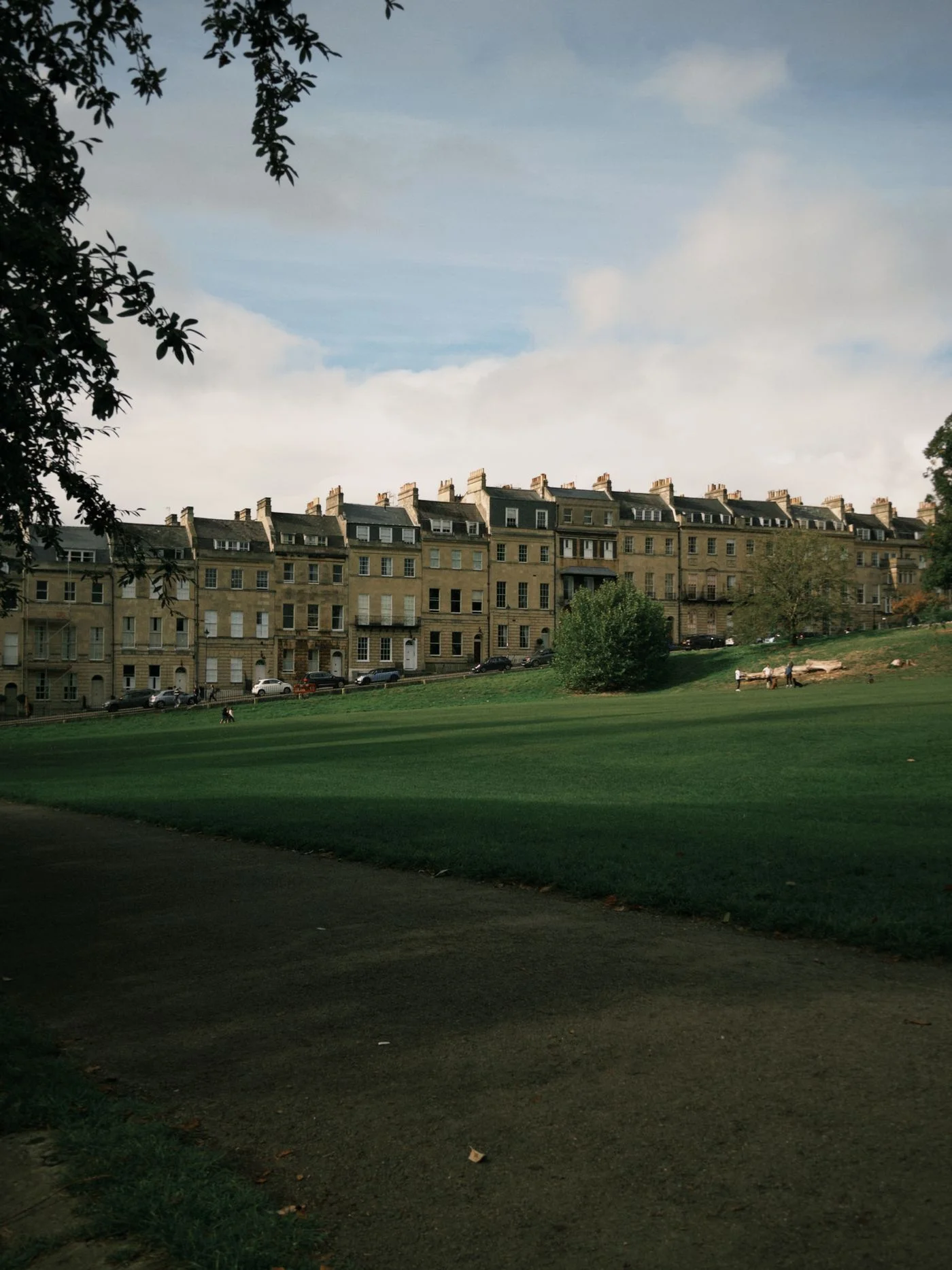Georgian houses at the Royal Crescent in Bath beside a green lawn.