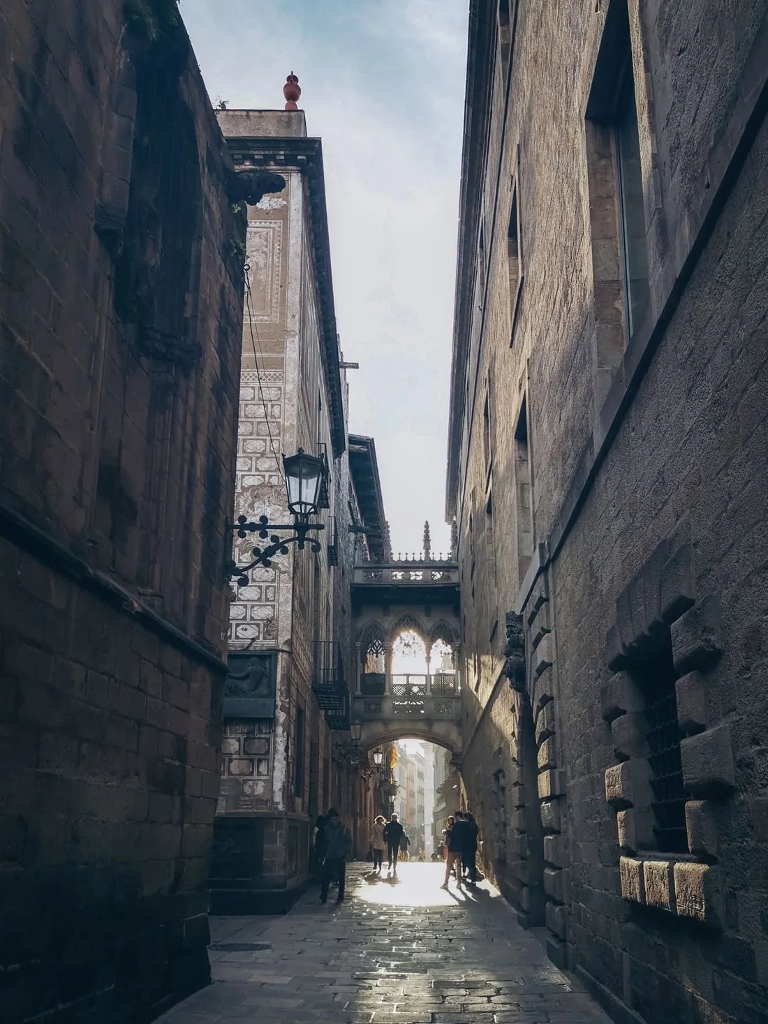Narrow sunlit street and stone architecture in Barcelona