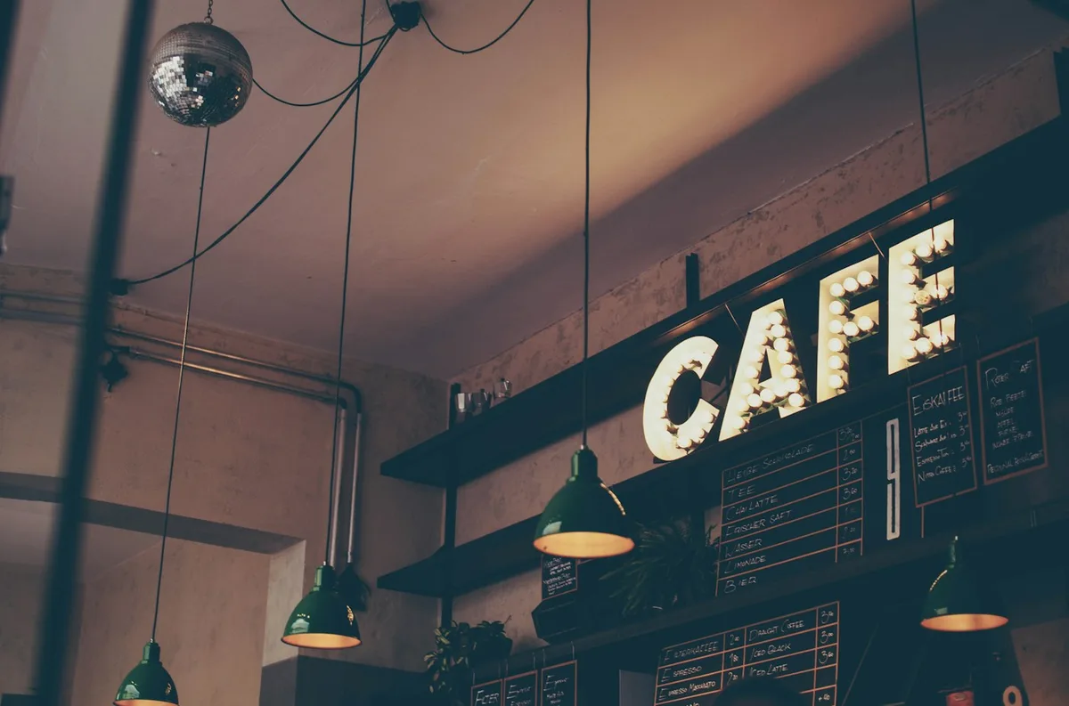 Warmly lit cafe with a large sign