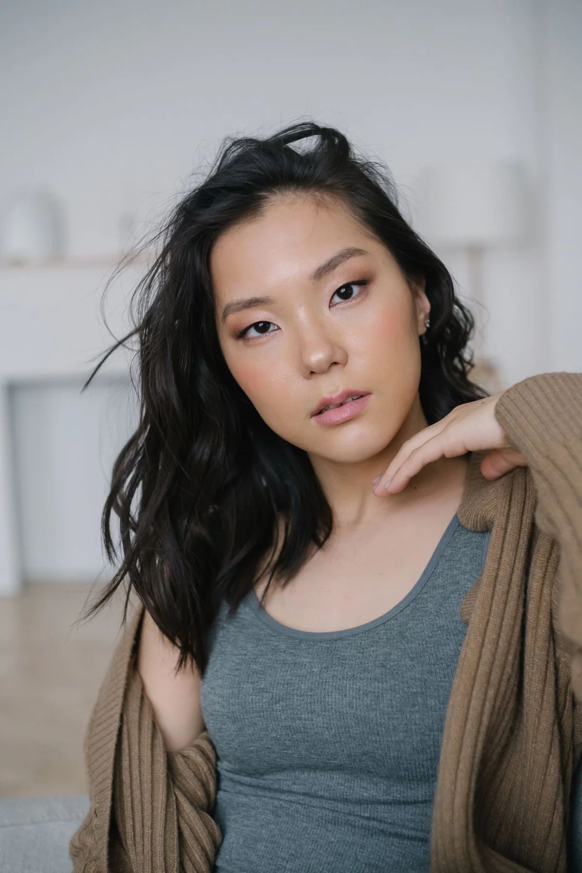 A woman wearing an open cardigan over a tank top.