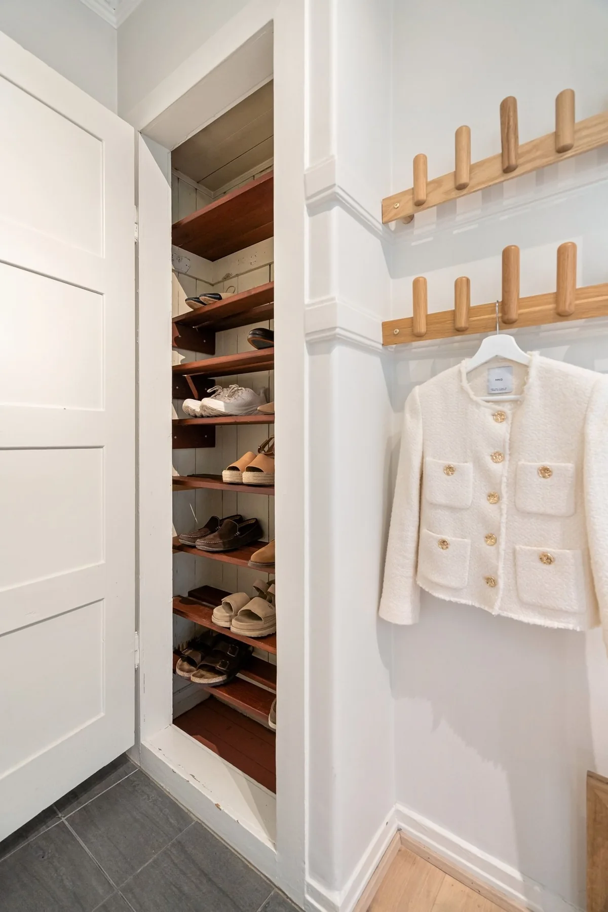 An open wardrobe with hanging clothing and shelves.