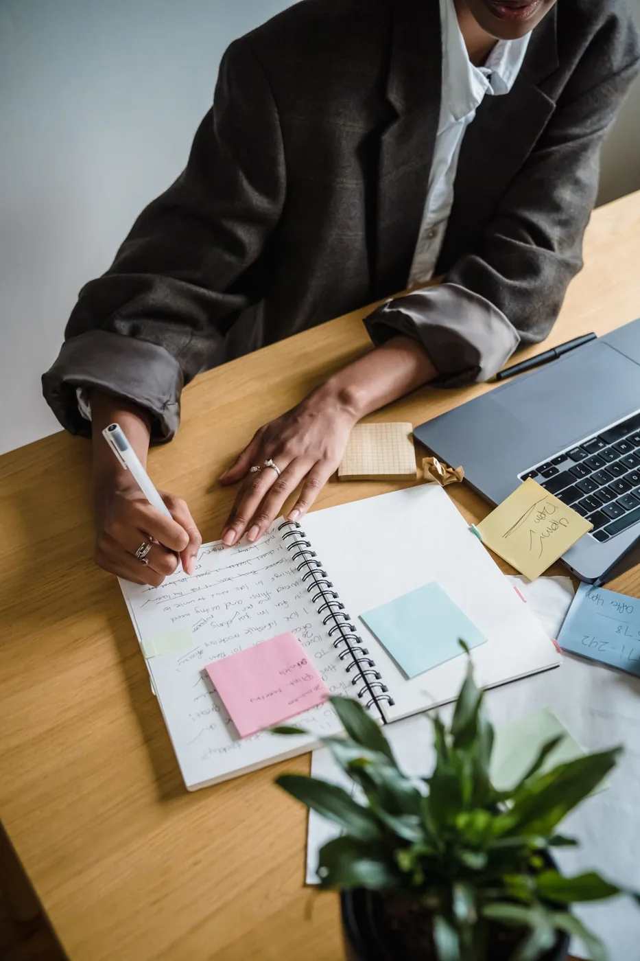 A person writing in a notebook at a desk.